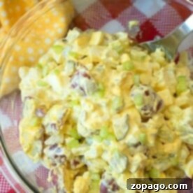 A bowl of easy potato salad, perfectly diced and mixed with crunchy celery, sits invitingly on a checkered tablecloth, showcasing the convenience of instant pot cooking.