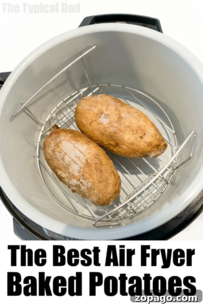 Crispy Foodi Baked Potatoes 7 Air fryer baked potatoes on a rustic wooden cutting board with fresh herbs