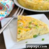Slice of frittata garnished with chives and cheese on a square white plate, with a fork beside it. A full instant pot breakfast casserole graces a round plate in the background, next to a colorful cloth.