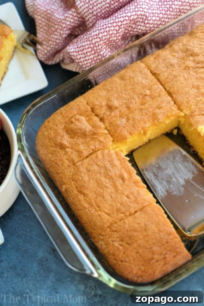Holiday Eggnog Pudding Cake 4 A warm, golden-brown egg nog pudding cake, fresh from the oven, nestled in a clear glass baking dish, emanating a cozy and inviting aroma.