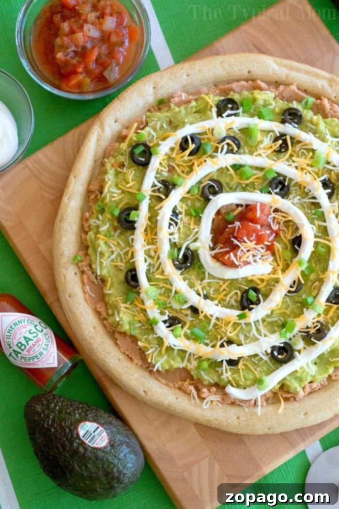 Loaded 7 Layer Pizza Dip 3 A close-up of the seven-layer dip pizza, showcasing its fresh and colorful layers.