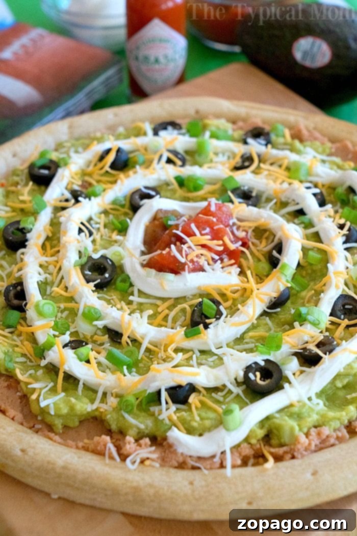 Loaded 7 Layer Pizza Dip 5 The 7 layer dip pizza, sliced and ready to serve, showcasing all the delicious layers.
