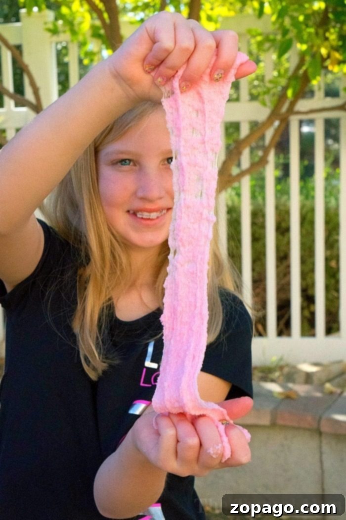 Observe the incredible stretch and satisfying crunch of this homemade snow slime. This image highlights the unique texture achieved with our easy recipe, showcasing why it's a favorite for sensory play and DIY fun. Crunchy Snow Slime Texture