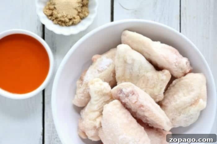 Effortless Pressure Cooker Frozen Chicken Wings 4 A large batch of frozen chicken wings ready to be cooked in an air fryer, illustrating the next step for crisping after pressure cooking.