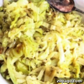 A bowl of cooked cabbage with a spoon, seasoned with black pepper, embodies the essence of simple cabbage recipes.