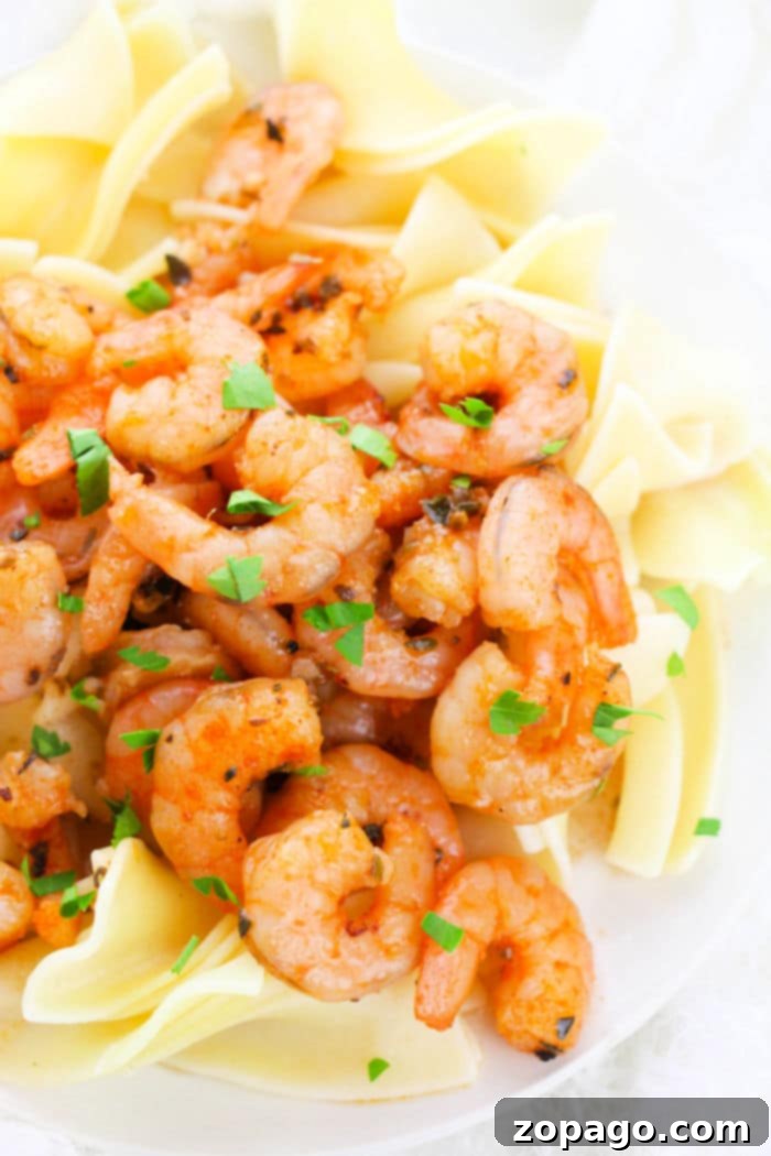 Garlic Shrimp with Zucchini Noodles 5 A plate of lemon garlic shrimp pasta garnished with chopped herbs.