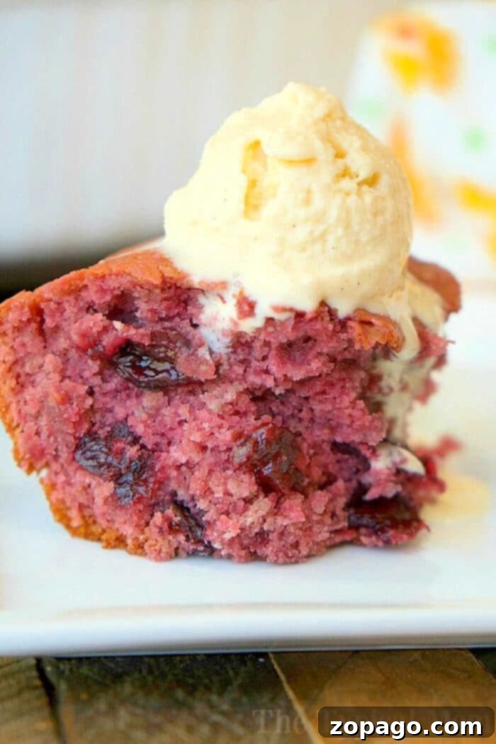 3 ingredient cherry pie filling dump cake for dessert! It's so simple to make even your kids can throw it together. It's really moist and packed with dark cherries or any other pie filling flavor you love. Cake mix baking has never been easier with this fun dump cake recipe. #cherry #pie #cake #dump #blueberry #easy #piefilling #cakemix #recipes Cherry-Pie-Cake - A delightful golden-brown cherry pie filling dump cake slice with a vibrant red cherry filling, served on a white plate. The cake's fluffy and moist texture is evident, highlighting the simplicity of this 3-ingredient recipe. In the background, the rest of the cake is still in the baking dish.