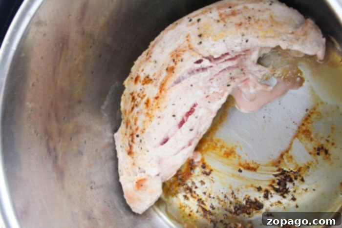 Sliced, tender pressure cooker pork tenderloin covered in a rich gravy, showcasing its delicious texture.