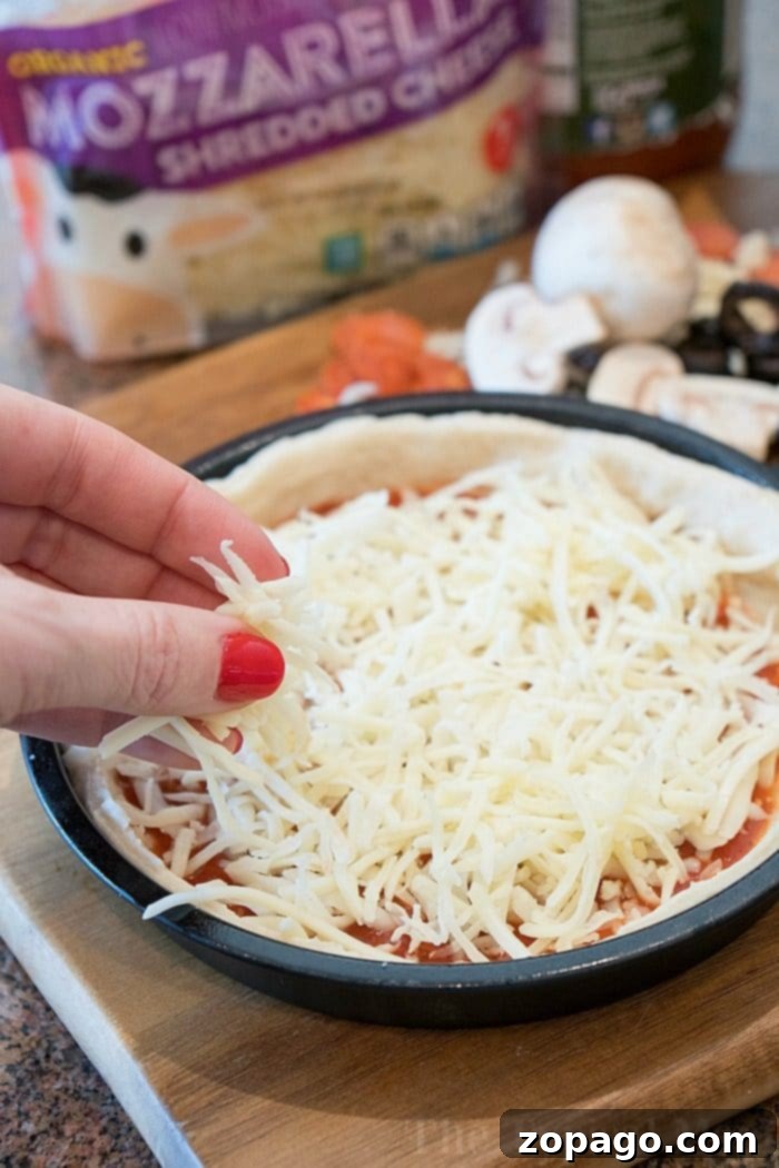 Easy Instant Pot Pizza 5 An Instant Pot deep dish pizza in a pan, fully topped with pepperoni and cheese, ready to be cooked. Additional toppings are scattered on a cutting board nearby.