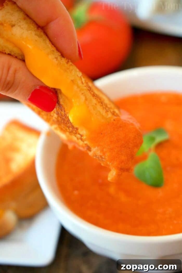 Perfectly Smooth Slow Cooker Tomato Soup Close-up of a bowl of creamy tomato soup with a swirl of cream and fresh basil