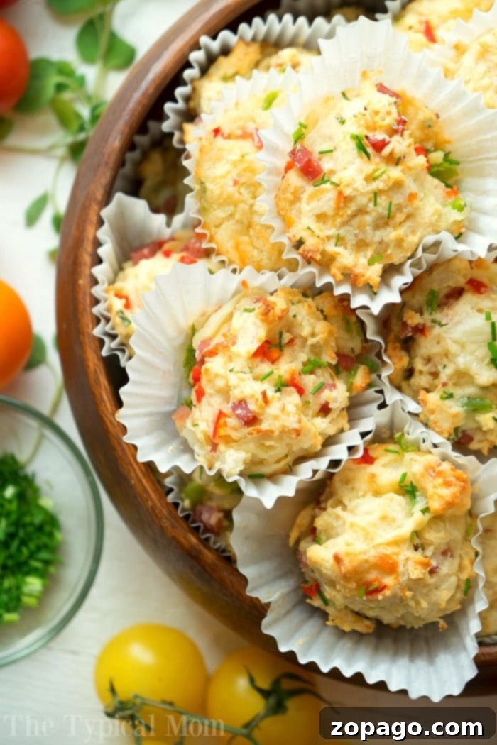 Savory Breakfast Muffins Ready to Serve A serving of savory breakfast muffins, garnished with fresh chives, arranged on a white plate with a fork.
