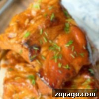 Two pieces of Crock-Pot Express ribs. Glazed and juicy, with a fork and cloth napkin partially visible in the background.