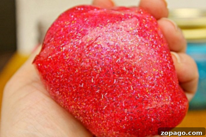 Vibrant Red Glitter Slime for Superhero Party Favors Red superhero glitter slime in a bowl, ready to be packaged for a party.