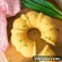 Savory cornbread bundt cake with chives on a wooden board.