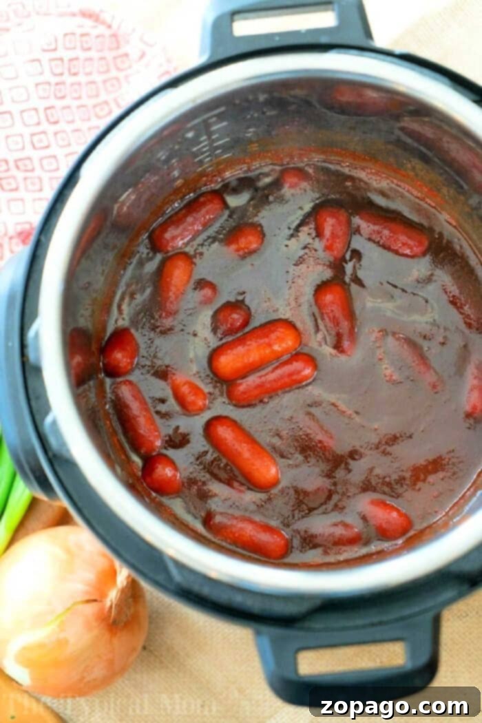 Instant Pot cocktail wiener recipe with just 3 ingredients! Both make for a delicious pressure cooker appetizer and very kid friendly. #instantpot #pressurecooker #crockpotexpress #cocktailweiners #appetizer #hotdogs #instantpotrecipes #thetypicalmom Delicious Instant Pot Cocktail Wieners with BBQ sauce, ready to serve as a quick and easy appetizer.