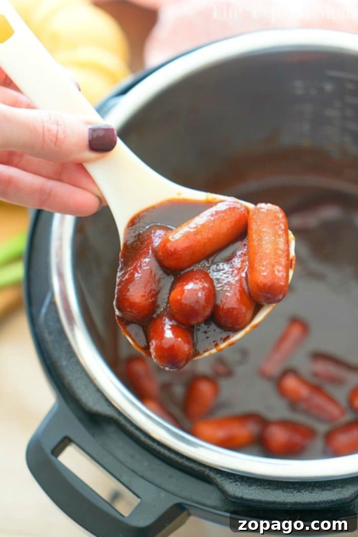 Instant Pot cocktail wiener recipe with just 3 ingredients! Both make for a delicious pressure cooker appetizer and very kid friendly. #instantpot #pressurecooker #crockpotexpress #cocktailweiners #appetizer #hotdogs #instantpotrecipes #thetypicalmom Close-up of Instant Pot Cocktail Wieners in a rich sauce, ready to be served with toothpicks.