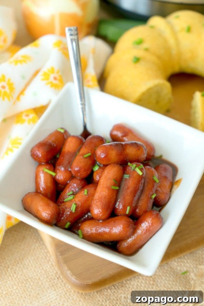 Instant Pot cocktail wiener recipe with just 3 ingredients! Both make for a delicious pressure cooker appetizer and very kid friendly. #instantpot #pressurecooker #crockpotexpress #cocktailweiners #appetizer #hotdogs #instantpotrecipes #thetypicalmom Instant Pot Cocktail Wiener Recipe: A close-up of delicious, saucy wieners ready to be served as an appetizer.