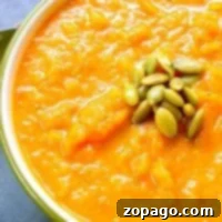 Golden Harvest Butternut Carrot Soup 2 Bowl of dairy-free butternut squash soup topped with green pumpkin seeds, inviting a wholesome and delicious experience.