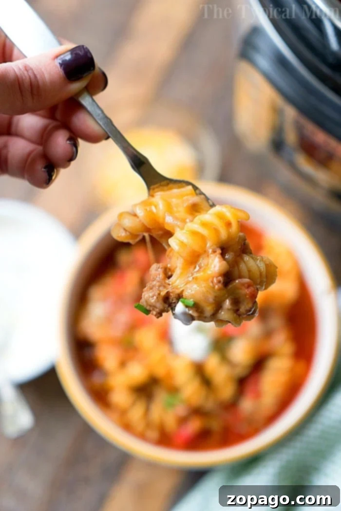 Instant Pot Taco Casserole: A comforting, cheesy ground beef pasta recipe for a delicious and quick family dinner. Hearty Instant Pot Taco Casserole with ground beef, cheese, and pasta, garnished with sour cream.