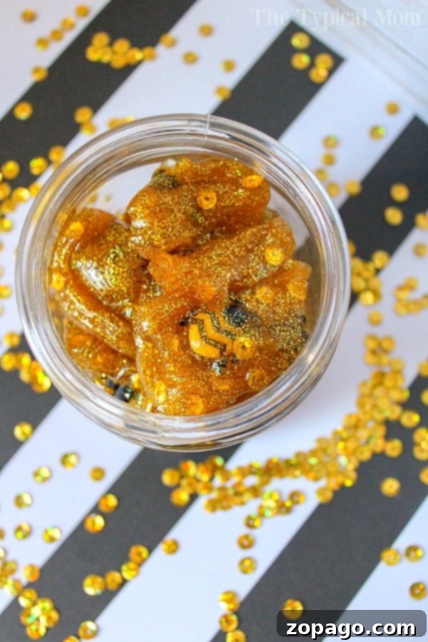 Discover hidden bees in your homemade honey slime! Close-up of golden honey slime with hidden bee toys.