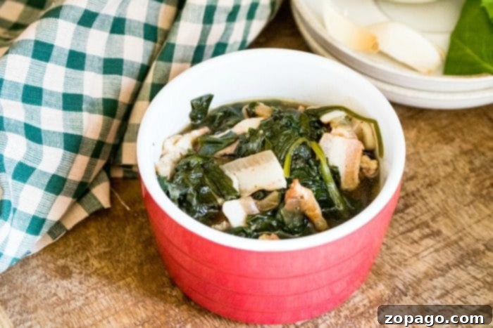 Instant Pot spinach is a great side dish recipe to make for your family. Add bacon and it's great. #instantpot #instantpotrecipes #spinach #vegetable #sidedish #healthy #thetypicalmom A bowl of Instant Pot spinach, garnished with fresh herbs, sits on a light wooden table, showcasing its inviting texture and vibrant green color.