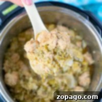 A hand holds a spoonful of chicken quinoa casserole above an Instant Pot, showcasing the delicious blend of flavors and textures in this pressure cooker delight.