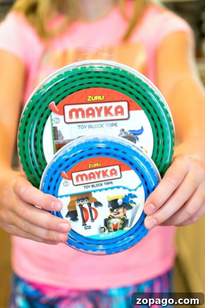 Children playing together, building with toy block tape on a cardboard box