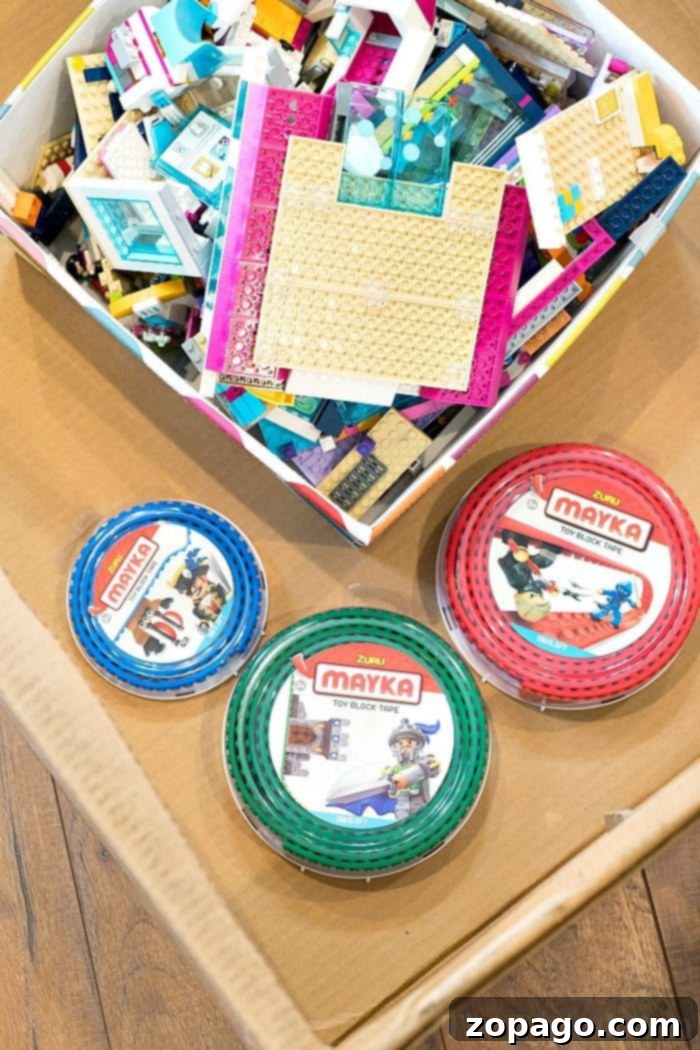 A child's hand placing a LEGO brick onto toy block tape adhered to a surface