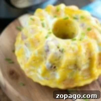 Bundt-shaped egg and ham casserole garnished with chives sits enticingly on a wooden board, seamlessly introducing a pressure cooker breakfast to your morning ritual.