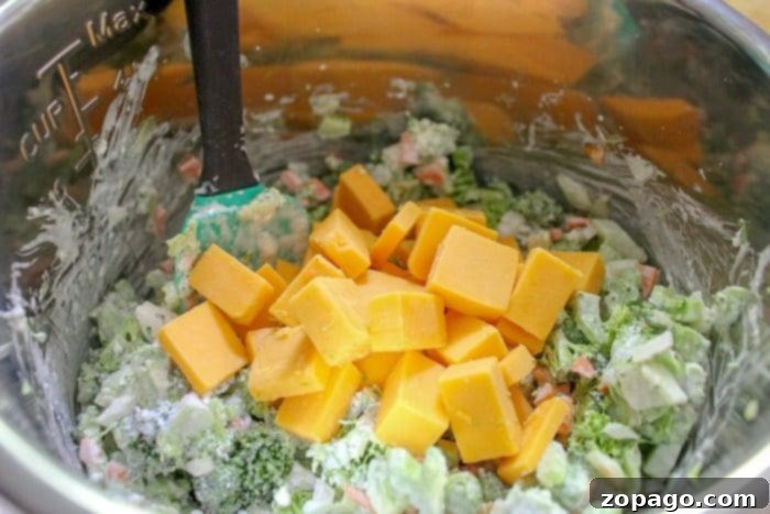 This easy pressure cooker broccoli cheese soup uses fresh vegetables and turns out creamy and delicious in your Instant Pot every time! #instantpot #pressurecooker #instantpotrecipes #soup #broccoli #cheese #creamy Close-up of Instant Pot broccoli potato cheese soup, rich and creamy, showing tender broccoli florets and melted cheese.