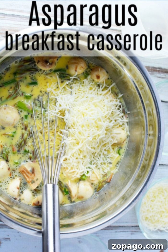 A perfect blend of fresh asparagus, savory eggs, and creamy cheese for a delightful breakfast casserole. A vibrant mixing bowl filled with fresh, chopped asparagus, sliced mushrooms, rich shredded cheese, and a creamy mixture of beaten eggs. A whisk rests beside the bowl, inviting you to create a delicious breakfast delight.