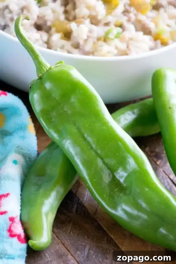 Delicious Pressure Cooker Sausage Rice Casserole with Hatch Chiles Green peppers are placed on a wooden surface next to a colorful cloth and a bowl of rice, ready to transform your meal into an instant pot sausage rice casserole.