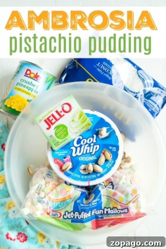 Pistachio pudding ambrosia is an amazing side dish or dessert! A cross between your favorite pistachio pudding and marshmallow ambrosia, you'll love it too. #pistachiopudding #ambrosia #dessert #marshmallow #pistachio #sidedish #thanksgiving A large serving bowl filled with Pistachio Pudding Ambrosia, garnished beautifully with crushed pistachios and mini marshmallows.