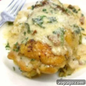 Perfect Instant Pot Bone In Chicken Thighs 3 A creamy chicken dish sits elegantly on a white plate, showcasing stuffed chicken breast alongside tender instant pot chicken thighs, bone-in, with a fork subtly placed in the background.
