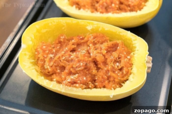 This is how to cook spaghetti squash fast, in just 7 minutes to be exact! Tender squash noodles are a healthy alternative for pasta and gluten free too. Instant Pot spaghetti squash is the best. #squash #spaghetti #fast #instantpot #pressurecooker #oven #baked #glutenfree #noodles #vegetable Delicious stuffed spaghetti squash with melted cheese, fresh from the oven, showcasing a healthy meal.