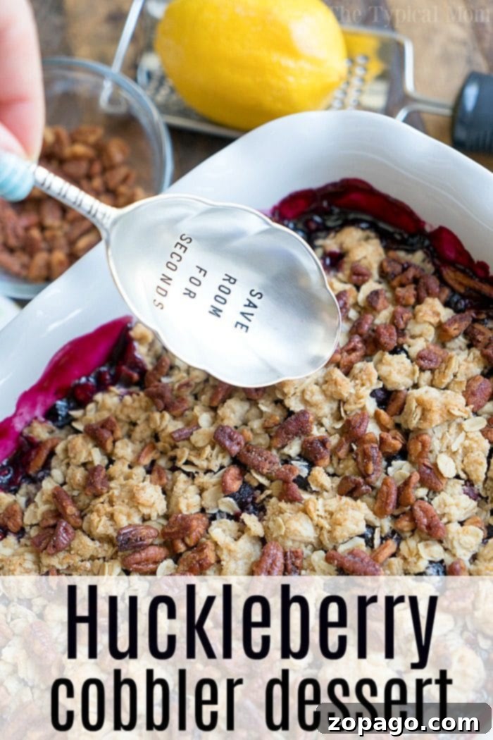 Delectable Huckleberry Cobbler with Crumble Topping A close-up of a rustic huckleberry crisp, highlighting the bubbling purple berry filling beneath a golden-brown oat and nut crumble, freshly baked and inviting.