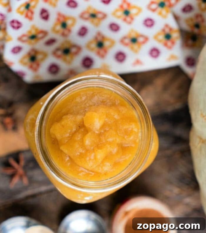 Autumn Pumpkin Delight 2 A jar of homemade Instant Pot pumpkin butter, rich in color, with a spoon resting in it.