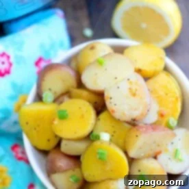Garlic Herb Instant Pot Baby Potatoes 4 A bowl of delicious instant pot potatoes, perfectly seasoned and topped with green onions, sits invitingly next to a lemon half and vibrant floral fabric.