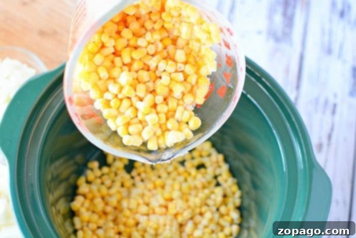 Crockpot corn chowder with potatoes and bacon recipe. Perfect soup for dinner packed with lots of vegetables and flavor! #crockpot #slowcooker #corn #chowder #potato #bacon #soup #crockpotrecipes #thetypicalmom Close-up of creamy slow cooker corn chowder with bacon and cheese toppings