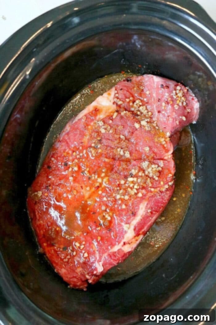 Korean Beef Slow Cooker Recipe 6 Close-up overhead shot of the tender chuck roast Korean beef, freshly shredded in the slow cooker with sauce.