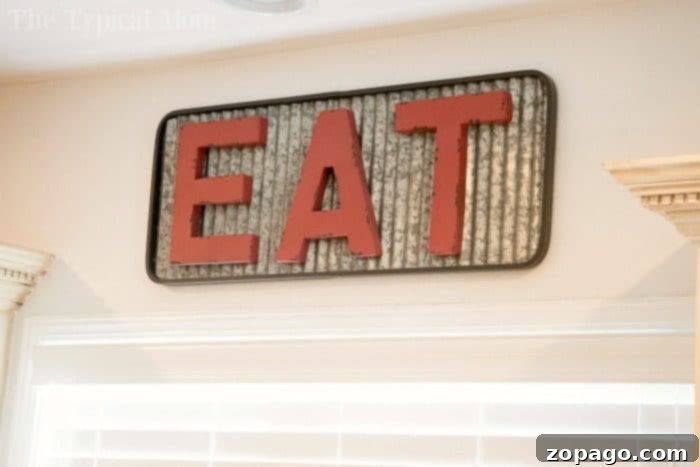 Charming 'Eat' Sign: A Farmhouse Kitchen Essential Decorative metal 'Eat' sign in a farmhouse kitchen