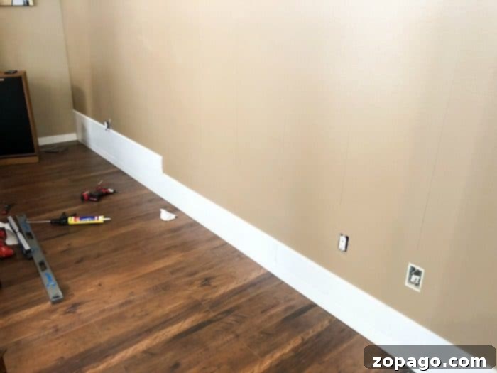 Shiplap Wall Installation in Progress Shiplap boards being installed on the living room wall