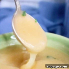 A spoon scoops up creamy rich pressure cooker gravy.