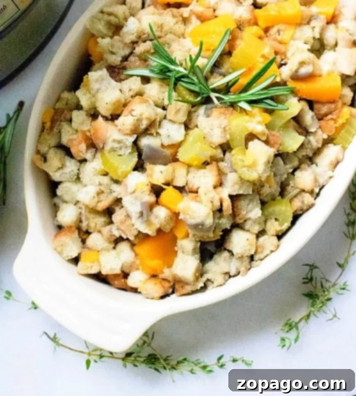 Easy Instant Pot Dressing 2 A beautiful white serving dish brimmed with delicious Instant Pot stuffing, garnished with fresh herbs like parsley and diced vegetables such as celery and golden butternut squash cubes, ready to be served.