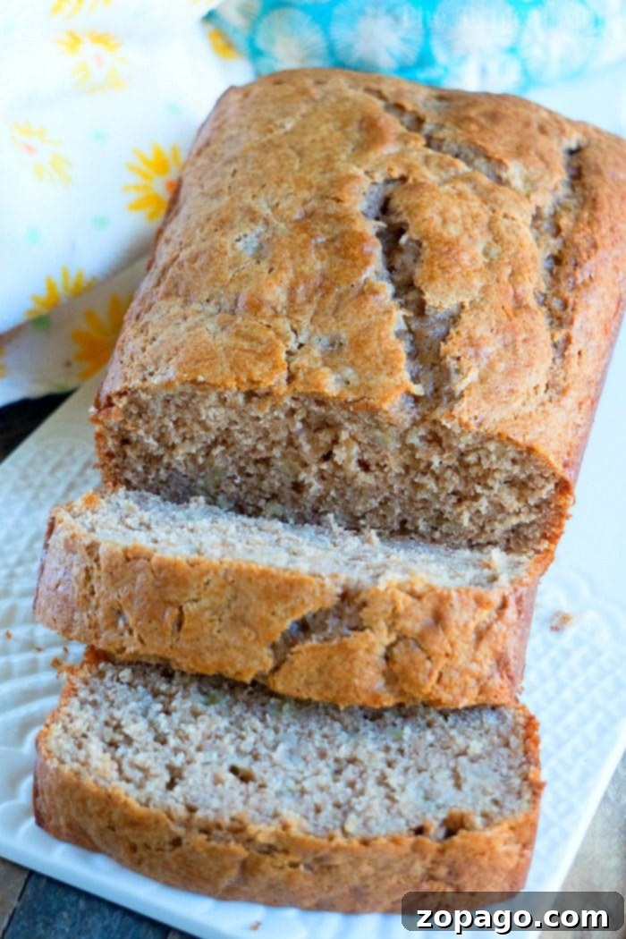 Easy 4-Ingredient Banana Bread 11 A beautifully presented slice of 4-ingredient banana bread on a wooden board.