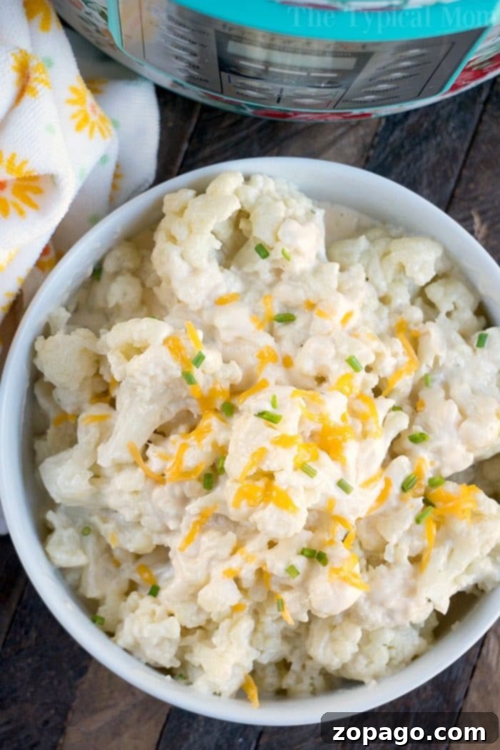 Creamy Instant Pot Cheesy Cauliflower 5 A hearty serving of Cheesy Instant Pot Cauliflower, garnished with fresh herbs, a perfect low-carb alternative to mac and cheese.