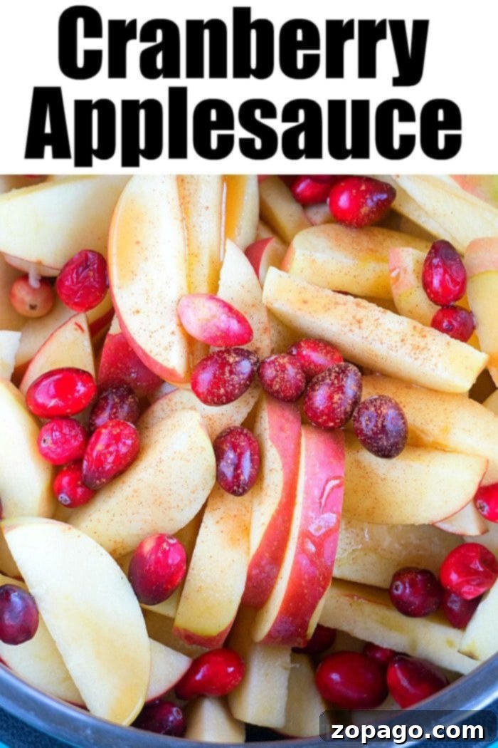 This Instant Pot cranberry applesauce is a great Thanksgiving or Christmas side dish or snack throughout the year. It's a great sweet homemade treat. #instantpot #instantpotrecipes #thetypicalmom #cranberry #applesauce #homemade #pressurecooker #crockpotexpress The vibrant mixture of apples and cranberries simmering in an Instant Pot, a beautiful sight during the cooking process.
