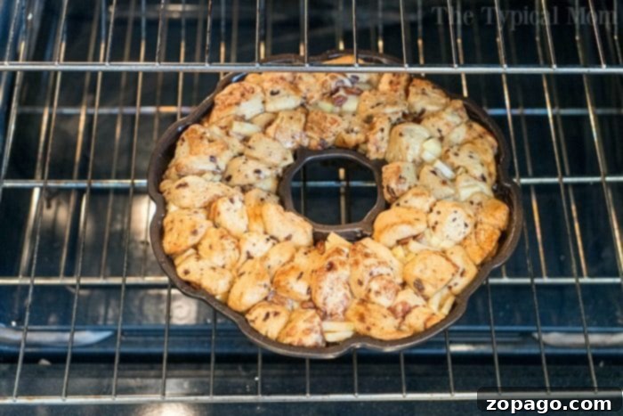 Caramel Apple Monkey Bread 5 Pillsbury cinnamon roll monkey bread with apple chunks, showing the layered arrangement in a bundt pan.