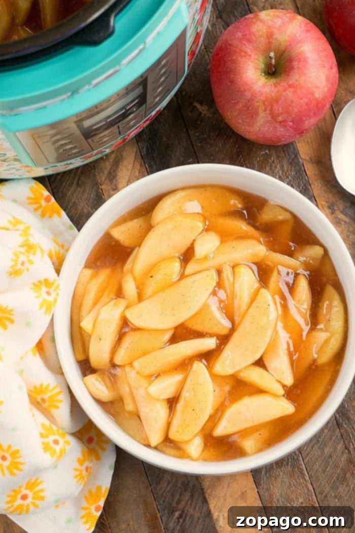 Easy homemade pressure cooker apple pie filling recipe you can make in about 20 minutes in your Instant Pot or a bit longer using our stovetop directions! #instantpot #applepiefilling #applerecipes #instantpotrecipes #pressurecooker #thetypicalmom #dessert A close-up shot of the Instant Pot inner pot filled with glistening, ready-to-use Pressure Cooker Apple Pie Filling, emphasizing its perfect consistency and inviting warmth.