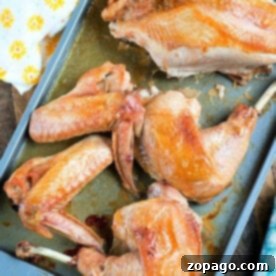Sheet pan turkey, golden and succulent, sits on a baking sheet alongside a vibrant yellow floral towel.